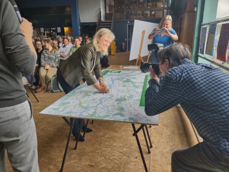 Wethouder Chantal Zeegers prikt het project Schiehaven Noord als eerste project op de Duurzaam Doorbouwen kaart.